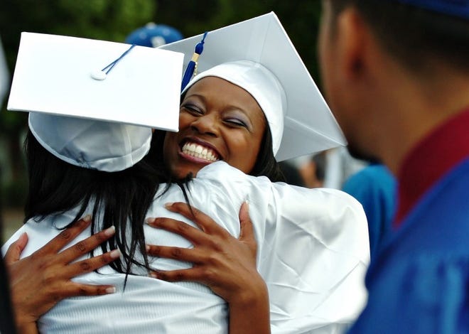 Graduates Indigo Johns (center) and Angel Wilson embrace Friday
before the start of commencement exercises for the Burlington City
High School class of 2011 at the Promenade in Burlington City.