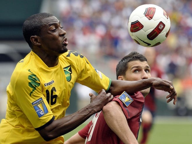 Jamaica's Omar Daley, left,  fights for the ball with Eric Lichaj of the U.S.