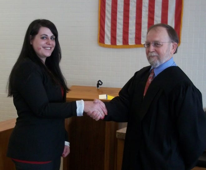 Vanessa Mudgett-Henderson shakes hands with Judge Lee Christofferson after she was sworn into the N.D. Bar Association.