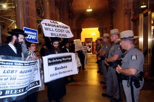 State Police move protesters against the same-sex marriage bill back to clear a hallway at the Capitol in Albany, N.Y., Monday, June 20, 2011.