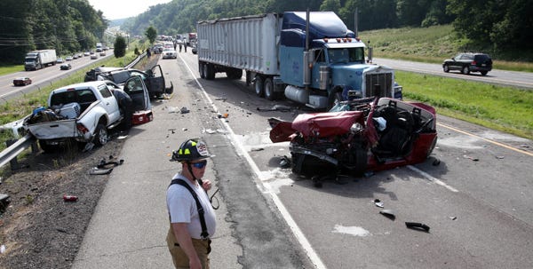 Westfall Fire Cpt. Howard Vobis crosses the scene as reconstruction begins on Interstate 84 on Monday afternoon. Three cars and two tractor-trailers were involved in a crash on the eastbound side of the highway in Westfall Township.
