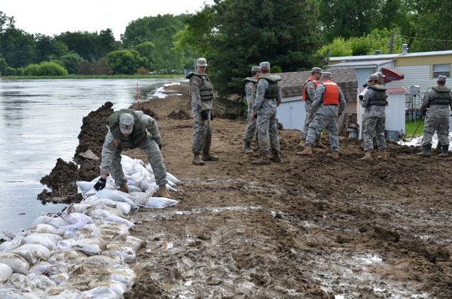 Soldiers with the North Dakota National Guard place sandbags on a temporary levee in Minot, N.D., on Wednesday.