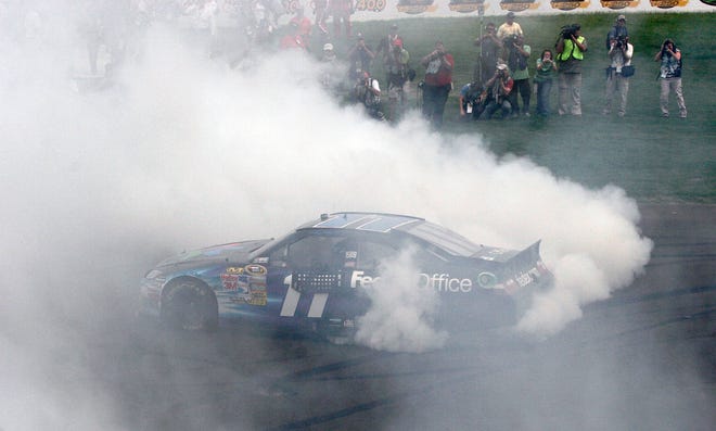 Denny Hamlin does a burnout after winning Sunday at Michigan international Speedway. The Associated Press
