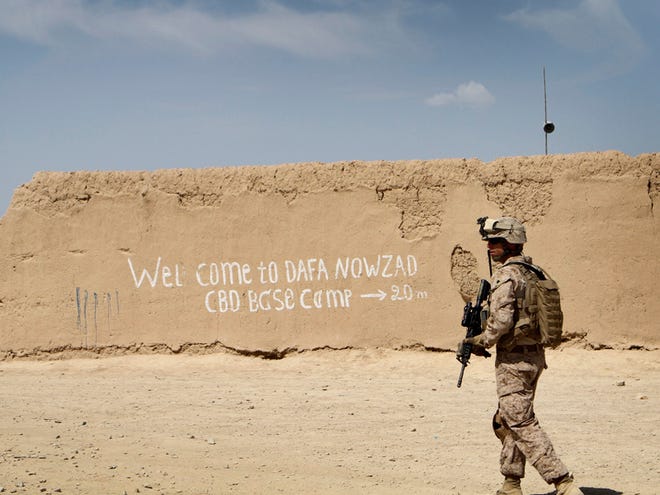 In this April 26, 2011 photo, a U.S. Marine with 3rd Battalion, 2nd Regiment patrols outside of Forward Operating Base Cafferata in Nawzad, Helmand province south of Kabul, Afghanistan. Pulling home the Americans he sent to war, President Barack Obama plans to announce Wednesday night the withdrawal of more than 30,000 troops from Afghanistan by the November 2012 election, hastening the end of the long conflict that has been more costly than ever envisioned when launched in response to the 2001 attacks on America.