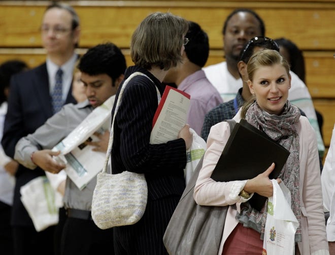 JOB SEEKERS stand in line at a job fair in Southfield, Mich., earlier this month. More Americans applied for unemployment benefits last week, adding to evidence that the labor market is weakening.