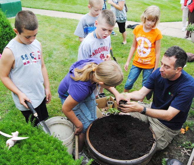 From left, B-PC Elementary School students Tyler Donaldson, Sky Lafary, Kanaan Wohlfeil, Remington Lindsey and Brenna Eddington helped Joel Gruver, WIU professor of agriculture, plant tubs at Fitch Manor Wednesday.