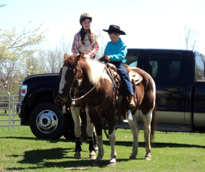 Harley-Anne and Cody sit on top of their horses before an event.