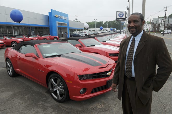 Gary V. Lee, business manager at DeSantis Chevrolet on Main Street in Brockton, stands nexto to one of the 46 red 2011 Camaro convertibles the dealership ordered.