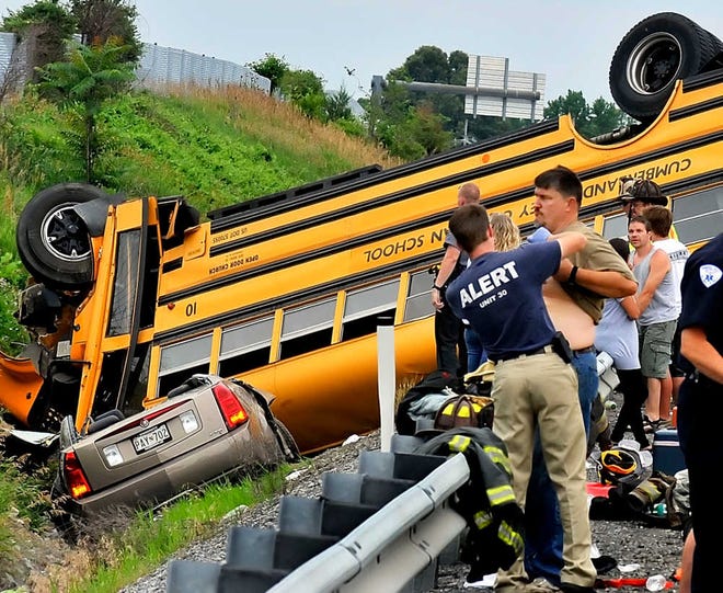 An adult passenger is checked out by medical personnel on the scene of auto and bus accident on I-81 in Chambersburg, Pa. Sunday, June 26, 2011. Pennsylvania State Police said the bus from Cumberland Valley Christian School in Chambersburg collided with a passenger vehicle, injuring more than two dozen people and closing the highway for hours. (AP Photo/The Herald-Mail, Ric Dugan)
