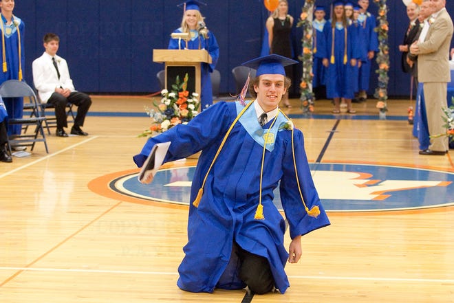 Jonah Pielow slides toward the audience after receiving his diploma.