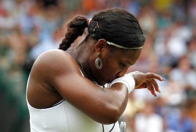 Serena Williams wipes her face during her 6-3, 7-6 (6) loss to Marion Bartoli on Monday at Wimbledon.