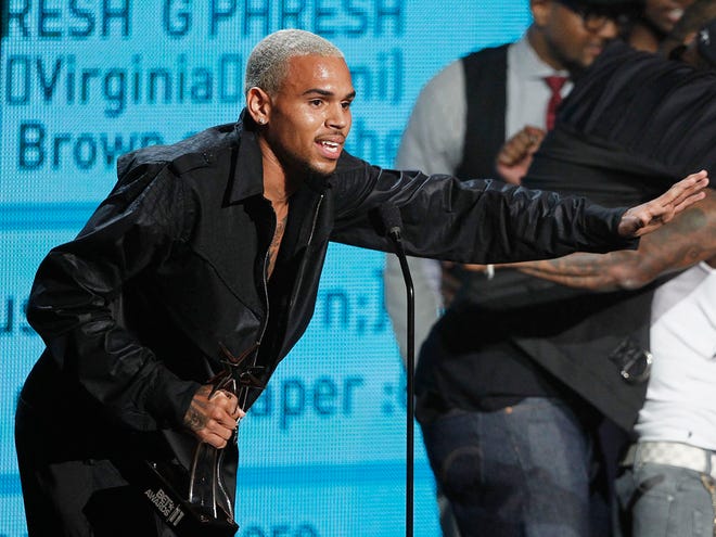 Chris Brown accepts the award for best collaboration for "Look at Me Now" with Lil Wayne and Busta Rhymes, far right, at the BET Awards on Sunday, June 26, 2011, in Los Angeles. (AP Photo)