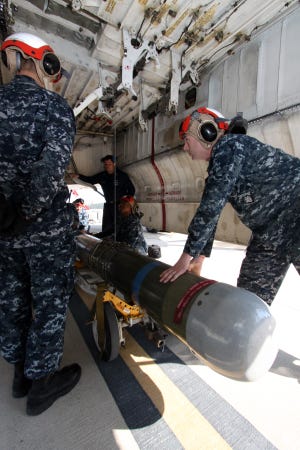 A VP-62 ordnance crew loads an inert training torpedo into the bomb bay of a P-3C Orion in preparation for their recent conventional weapons technical proficiency inspection.