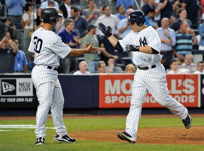 New York Yankees' Jorge Posada, left, greets Russell Martin at home plate after Martin hit a three-run home run off Milwaukee Brewers starting pitcher Shaun Marcum during the fourth inning of a baseball game Wednesday, June 29, 2011, at Yankee Stadium in New York. (AP Photo/Kathy Kmonicek)