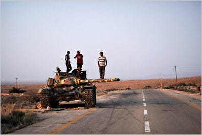 Young men atop a destroyed tank on Thursday near Rujban, Libya.