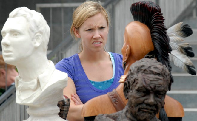 Adrienne Young of Yorkville studies a wood sculpture by Greg Lowe of Utica called "Big Mohawk" at the 2011 MWPAI Arts Festival Sidewalk Art Show in front of the MWPAI Museum of Art in Utica on Friday, July 1, 2011. The festival, which features a number of events and attractions, will run through Wednesday.
