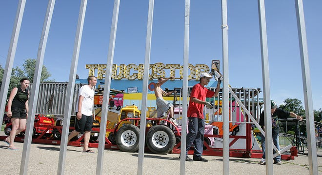 Lisko & Son Amusements’ set-up crew team up to get the “Truckstop” ride up and running for opening day of the Richville Homecoming Festival on Wednesday. The Richville Homecoming, at Richville Community Park, 6655 Navarre Rd. SW, continues tonight and Saturday, with a fireworks show set for this evening at dark.