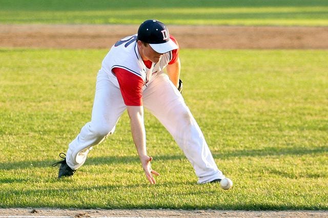 EJ Hersom/Staff photographer Dover's Chris White tries to barehand a ground ball near third base during American Legion District A action Friday night in Rochester.