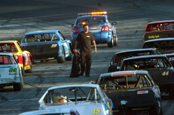 Joe Coates walks pass the limited sportsman cars as he wants to talk to the oficials during the limited sportsman at Thompson International Speedway.
