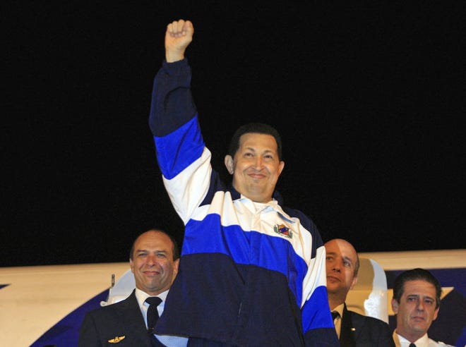 Venezuela's President Hugo Chavez raises a fist into the air before his departure to Venezuela from the Jose Marti International Airport in Havana, Cuba earlier today