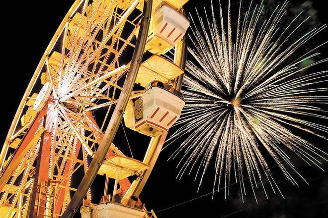 Fireworks explode behind the giant Ferris wheel at the Warwick Firemen's Carnival in 2010.
