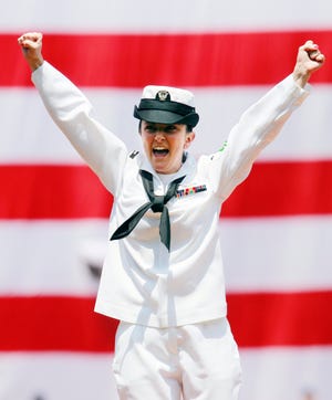 Petty Officer Bridget Lydon of Quincy celebrates after throwing out the first pitch before a baseball game between the Boston Red Sox and the Toronto Blue Jays in Boston, Monday, July 4, 2011. With her family in attendance, Lydon made a surprise visit from her ship, the USS Ronald Reagan, as the Red Sox honored America's military personnel on the Fourth of July.