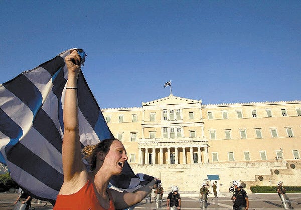 A protester shouts a slogan as she waves the Greek flag outside the Parliament in Athens on Thursday. Global stocks pushed higher once again on Thursday after Greece cleared the final hurdle required to get bailout cash needed to avert a potential debt default next month.