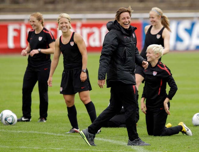United States' Abby Wambach, center in jacket, smiles with teammates during a training session in preparation for a match against Sweden during the Women's Soccer World Cup in Wolfsburg, Germany, Monday, July 4, 2011. (AP Photo/Marcio Jose Sanchez)