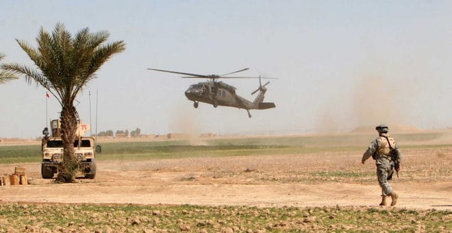 A U.S. helicopter lands in the field as a U.S. soldier stands
guard outside Samarra, Iraq, in March 2006.