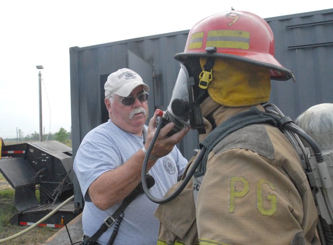 (left to right) Mike Healy, a lead instructor from Central Nyack Fire Department, helps Andrew Johannesen, a 3rd assistant chief from the Greenville Fire Company in securing his breathing mask shortly before going into a flashover simulator during the hands-on training program as part of the FIRE 2011 Conference and Expo, June 17, 2011, in Verona, NY.