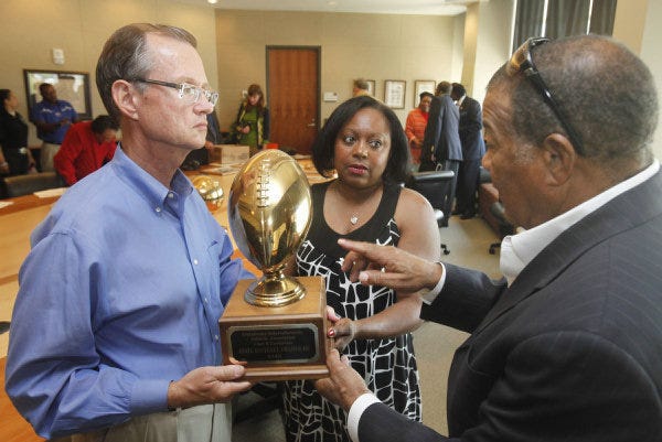 Bob Blackburn, left, executive director of the Oklahoma Historical Society, holds a trophy from Shawnee Dunbar High School. At center is Shirley Campbell and at right is Oklahoma County District Judge Kenneth Watson. The Shawnee Dunbar High School Alumni Association presented a collection to the Oklahoma History Center in June. PHOTO BY PAUL HELLSTERN, THE OKLAHOMAN PAUL HELLSTERN