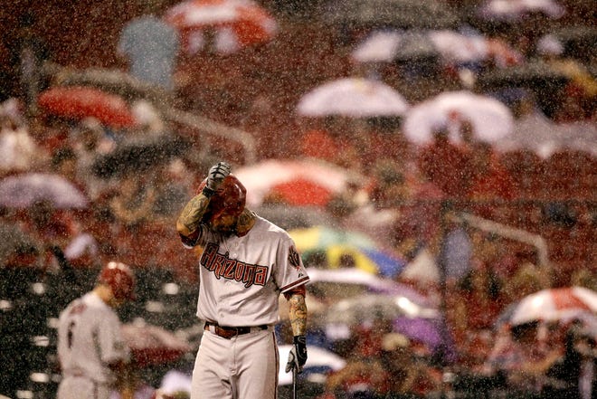 Diamondbacks' Ryan Roberts wipes off his face as he bats in a steady rain fall during the sixth inning of a baseball game against the St. Louis Cardinals, Thursday, July 7, 2011, in St. Louis. A rain delay was called soon after. (AP Photo/Jeff Roberson)
