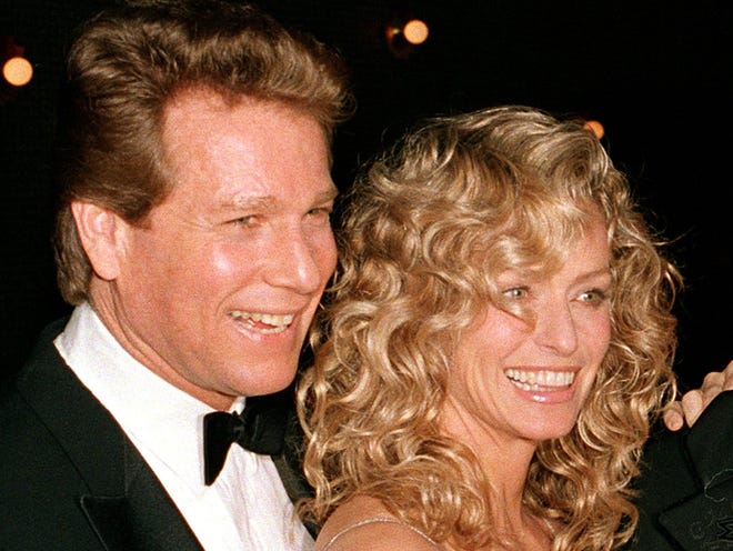 In this March 5, 1989 file photo, actors Ryan O'Neal, left, and Farrah Fawcett are shown at the premiere of the film. "Chances Are," in New York. The University of Texas system sued Fawcett's longtime partner, Ryan O'Neal, asking that a federal judge order him to turn over an Andy Warhol painting of the model and actress that they claim he is keeping without permission. (AP Photo/Ray Stubblebine, file)