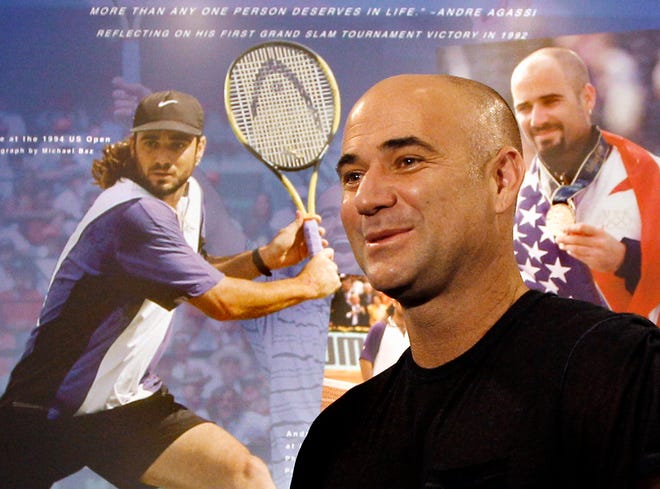 Tennis great Andre Agassi reacts as he looks at an exhibit dedicated to him at the International Tennis Hall of Fame, Friday, July 8, 2011, in Newport, R.I. Agassi will be inducted into the Hall of Fame on Saturday. (AP Photo/Elise Amendola)