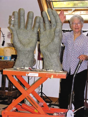 Helen Winebaum, the wife of artist Sumner Winebaum, stands next to a 3-ft tall "Praying Hands" sculpture slated to be installed next to Temple Israel later this fall.
courtesy photo