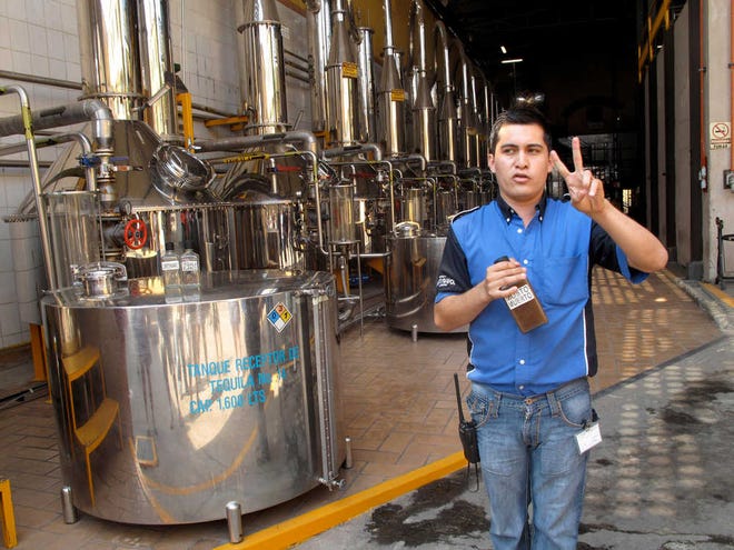 This April 2011 photo shows a tour guide speaking at the distillery plant at Herradura Tequila as he explains that the fermented agave juice is distilled twice in stainless steel stills before it is bottled during a tour in Tequila, Mexico. Tequila consumption has increased 45 percent in the U.S. over the past five years. It's no wonder, then, that the country is waking up to the tourism power of tequila, the drink, and Tequila, the place _ the center of the farming region of the prickly Weber blue agave plants from which the spirit is distilled.  (AP Photo/Tracie Cone)