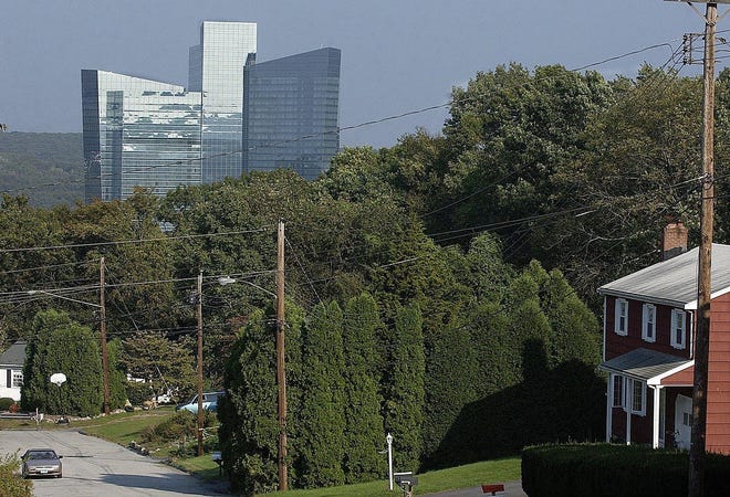A car travels up Holly Hill Drive in Montville as the Mohegan Sun hotel looms in the background.
