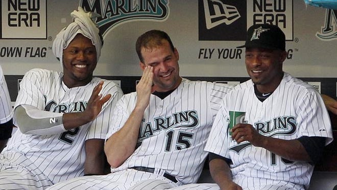 Marlins first baseman Gaby Sanchez (15) and outfielder Dewayne Wise (right) react after shortstop Hanley Ramirez (2) wrapped a towel around his head as they sit in the dugout during the second inning of a 6-1 win over the Astros on Saturday, July 9, 2011.