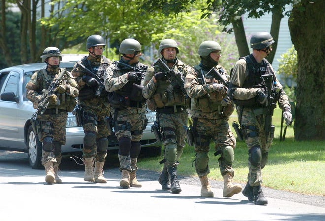 Members of the Satucket Regional Tactical Team, made up of police officers from Bridgewater, East Bridgewater, West Bridgewater and Middleboro, search for Albert DeAndrade on High Street in Bridgewater on Wednesday, July 6, 2011.