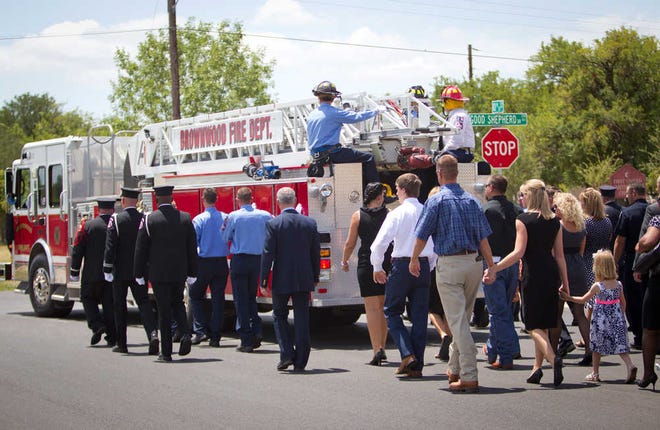 Family members follow the procession with the fire truck carrying the casket of Brownwood firefighter Shannon Stone during his funeral on Monday in Brownwood.