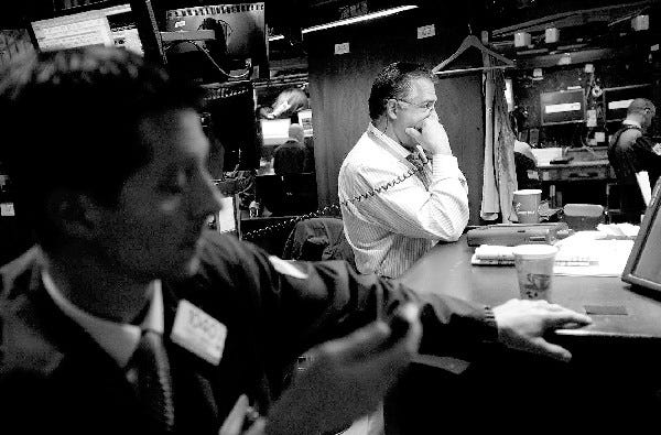 Traders work on the floor at the New York Stock Exchange in New York. As an Aug. 2 deadline nears for the U.S. to raise its debt ceiling, stocks and bonds have barely moved.