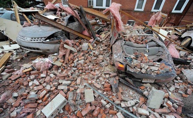 Bricks and debris that fell from a building lay on top of cars after a report of a tornado in Springfield, Mass., Wednesday, June 1, 2011. An apparent tornado struck downtown Springfield, one of Massachusetts' largest cities, scattering debris, toppling trees, and frightening workers and residents. (AP Photo/Jessica Hill)