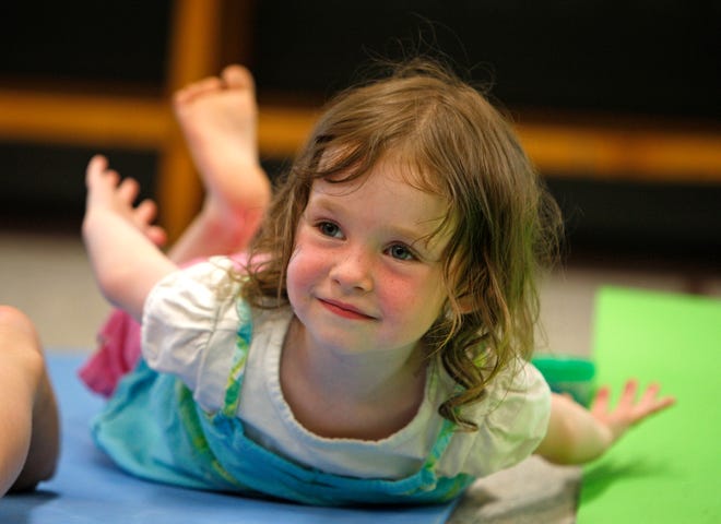 Riley Marshall, 3, of Hanson, practices her shark pose in yoga class at the Hanson Public Library.