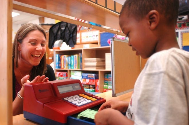 Ms Jen Polis, a teacher at Peter Muschal Elementary School in
Bordentown, goes to the "post office" to buy some stamps from
pre-schooler Myles Hansford who must dole out some change, during
class where special education students are being included in
regular education classrooms.