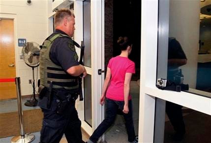 Casey Anthony, right, walks out of the Orange County Jail escorted by a sheriff's deputy during her release in Orlando, Fla., early Sunday, July 17, 2011. Anthony was acquitted last week of murder in the death of her daughter, Caylee.