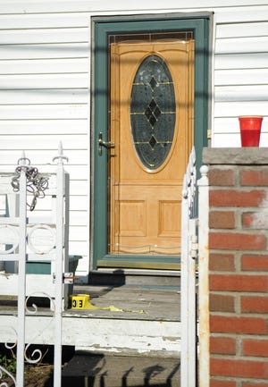 A roll of police tape and a plastic cup remain on the porch of 73 Emmet St. in Brockton on Sunday