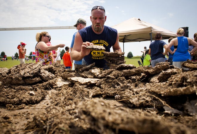 Jeremy Ackerman picks through the selection of cow chips, looking for the perfect piece to throw Saturday during the Illinois Championship Cow Chip Throw in Chatham. Ackerman finished second. Justin L. Fowler/The State Journal-Register