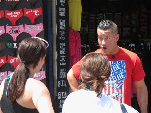 Michael "The Situation" Sorrentino speaks with Michelle Diaz of
Philadelphia, left, and Patricia Garcia, also of Philadelphia, on
the boardwalk in Seaside Heights, N.J., during a break in taping of
an episode of the MTV series "Jersey Shore," Friday, July 15, 2011.
A new nationwide poll finds the show's depiction of a group of
hard-drinking, foul-mouthed 20-somethings has not hurt New Jersey's
national image, and may help it in some small ways.