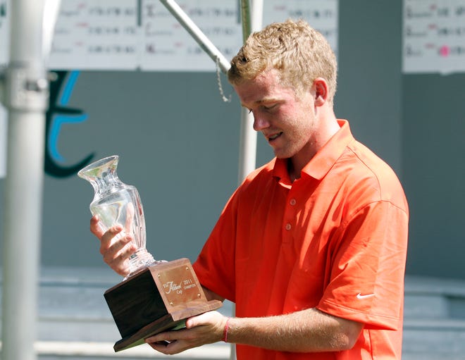 Kevin Flack looks down at his trophy after winning the Aldeen Cup Sunday, July 17, 2011, at the Aldeen Golf Course in Rockford.