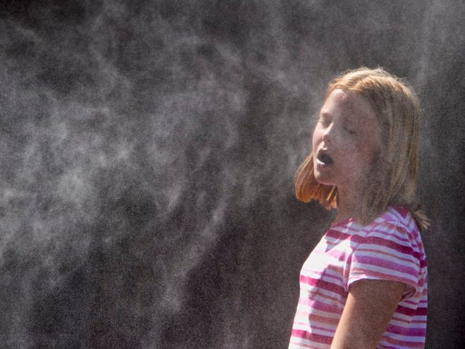A child cools off in mist at the Henry Doorly Zoo in Omaha, Neb., Monday, July 18, 2011. A heat wave is smothering the Midwest with a heat index well over 100 in most places. (AP Photo/Nati Harnik)